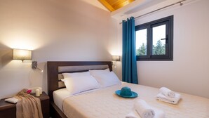 A bedroom with a bed, nightstands, a window with curtains, and a view of trees. - Apartment Deluxe Suite with Sea View B close to Beach with Shared Pool & Wi-Fi (?e???da)