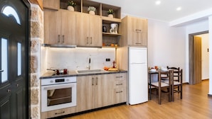 Una cocina moderna con armarios de madera, horno empotrado y un comedor con mesa y sillas.