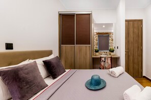 Ein Hotelzimmer mit einem Bett, einem Holzschrank, einem kleinen Badezimmer und einer Tür.