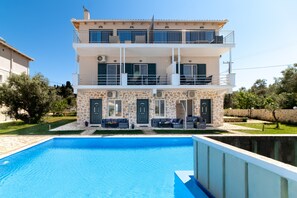 A two-story building with a swimming pool, stone facade, balconies, and outdoor seating. - Apartment "Superior Apartment A" close to the Beach with Shared Pool & Wi-Fi (?e???da)