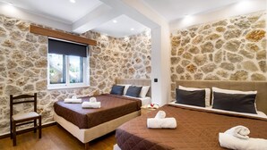 A room with two beds, stone walls, a wooden chair, and a window with a view. - Apartment with Pool View, Sea View, Wi-Fi & Terrace (?e???da)