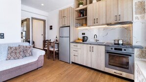 A modern kitchen with wooden cabinets, a built-in oven, and a marble backsplash. - Apartment with Pool View, Sea View, Wi-Fi & Terrace (?e???da)