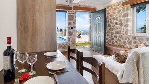 A dining table set with plates, glasses, and cutlery, a bottle of wine, and a red napkin. - Apartment with Pool View, Sea View, Wi-Fi & Terrace (?e???da)