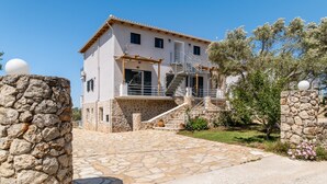 A two-story house with a stone facade, a staircase leading to the upper floor, and a paved driveway. - 'Apartment with Sea View B' with Pool, Garden, Terrace & Wi-Fi (?e???da)