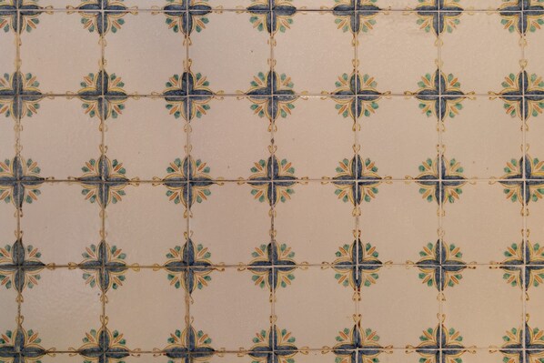 Una pared con azulejos y un patrón geométrico repetitivo.