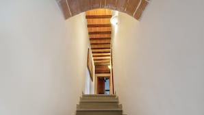 A staircase leading to a room with a brick archway above.