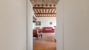 An interior with a red sofa, a wooden chair, a painting, and a tiled floor. - Universal Harmony - Usignolo Agriturismo with Mountain View and Shared Pool (Dicomano)