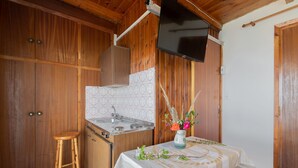 A wooden interior with a kitchen area, including a stove, sink, and wooden cabinets. - Agnadi Sea View Apartments (Zakynthos)