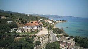 A coastal village with terraced houses, a winding road, and a view of the sea. - Agnadi Sea View Apartments (Zakynthos)