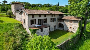 A stone house with a courtyard, featuring a dining area with outdoor seating. - Casale Lucrezia - Salò (Salò)