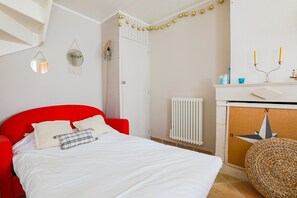 A bedroom with a red headboard, white bedding, a bedside table with a lamp, and a wall-mounted mirror. - House for 2 adults & 2 kids, central Ars-en-Ré (Ars-en-Ré)