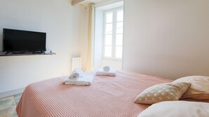 A bedroom with a bed, a television on the wall, and a window. - House for 2 adults & 2 kids, central Ars-en-Ré (Ars-en-Ré)