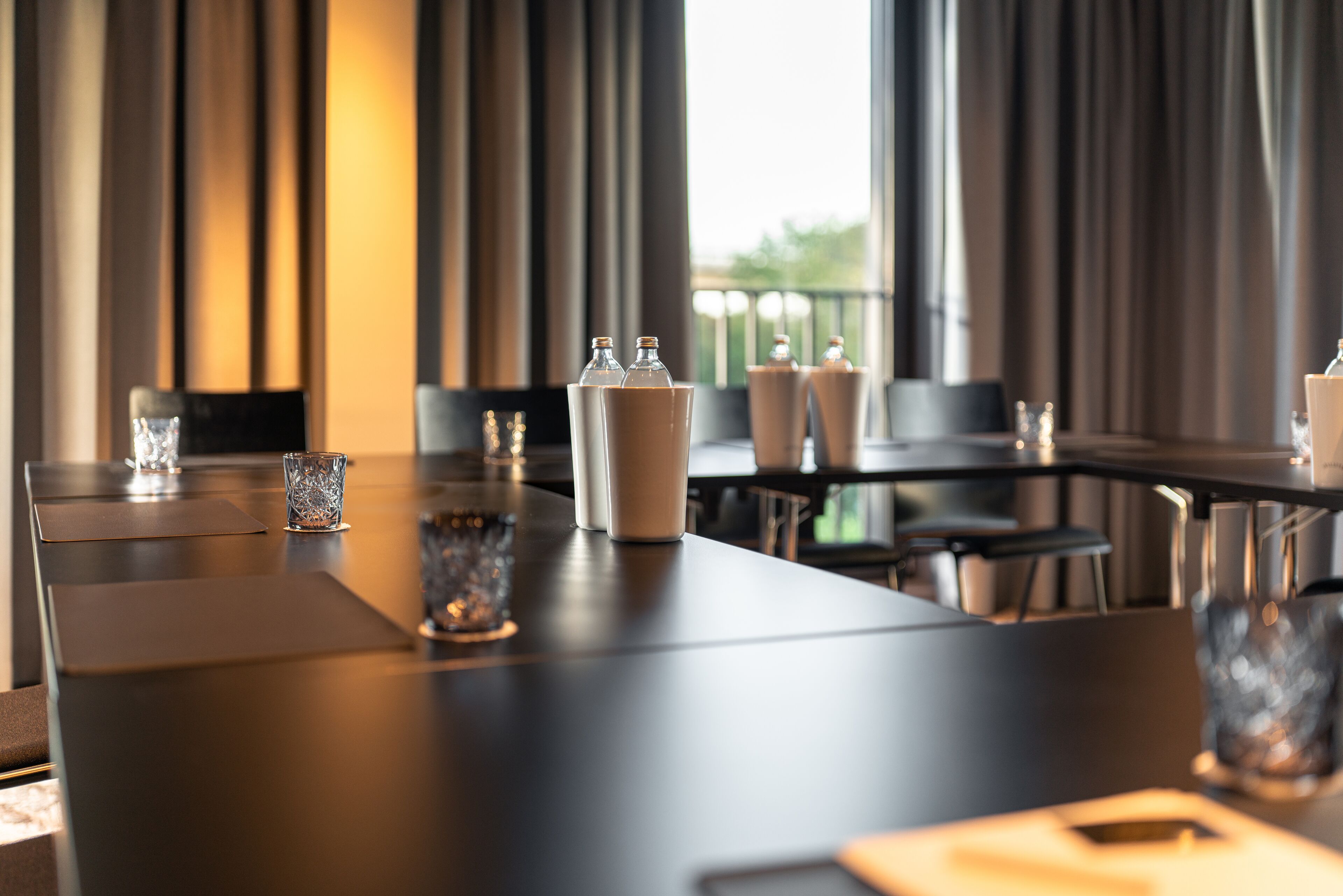 Een moderne eetruimte in een hotel, met een lange tafel gedekt voor een vergadering.