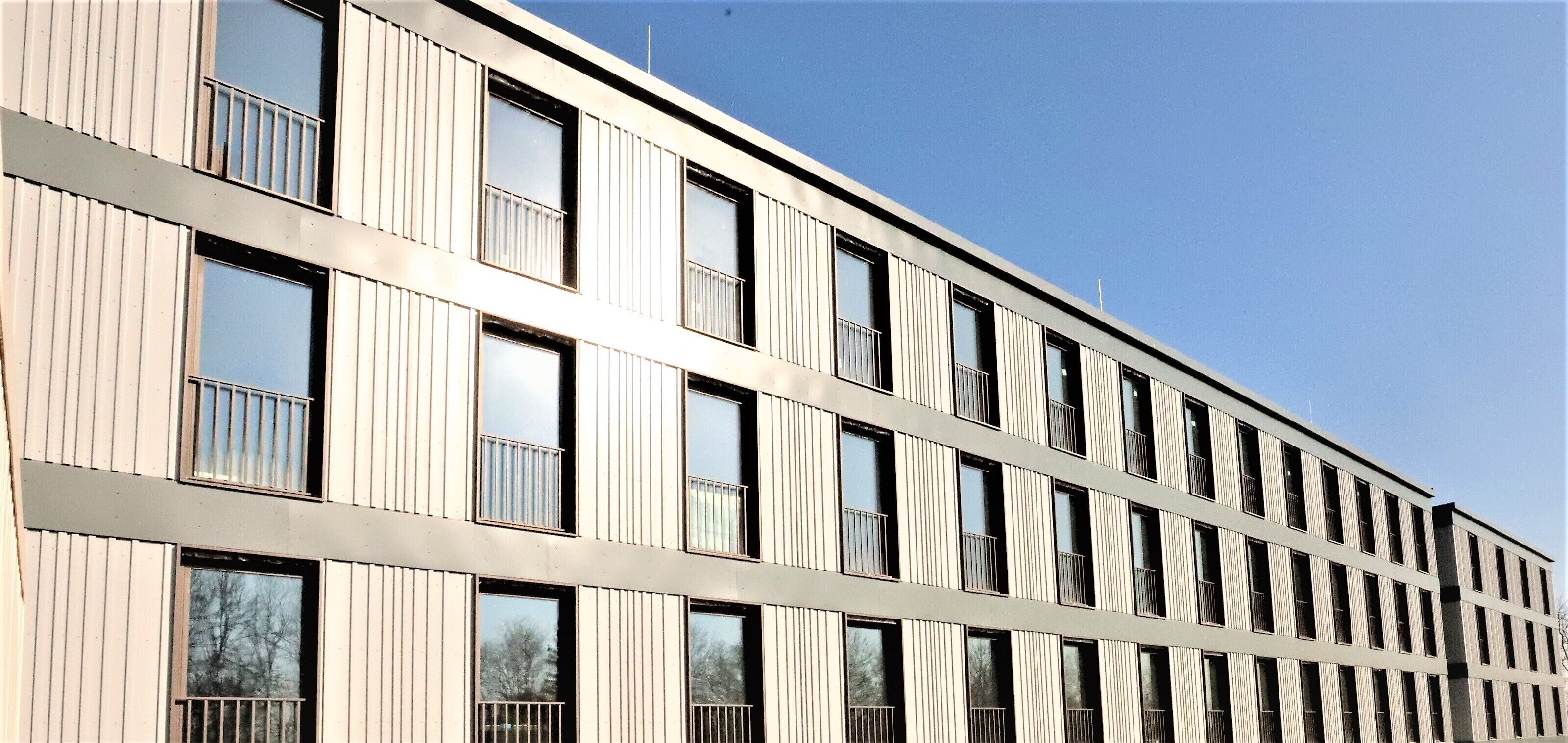 A modern building with a grid of windows and balconies.