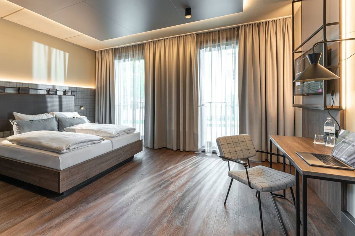 Hypo-allergenic bedding, desk, laptop workspace, blackout drapes