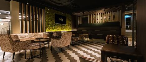 A modern lounge area with patterned sofas, a coffee table, and a dining table.