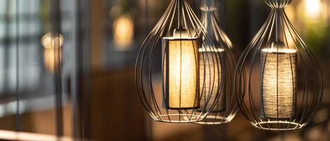 Three hanging pendant lights with a metallic frame and a textured glass cover.