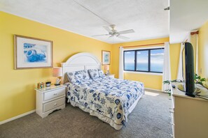 A bedroom with a bed, a nightstand, a ceiling fan, and a window with a view. - XPLORIE ACTIVITIES & LINENS INCLUDED*! Plaza 3BR/2BA END UNIT with oceanfront & bayside balconies! (Ocean City)