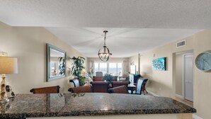 A spacious living area with a large granite island, a dining table, and comfortable seating. - Sandy Key 716: 2 BR / 2 BA Gulf Front Condo in Perdido Key, FL.  Sleeps 6 (Pensacola)