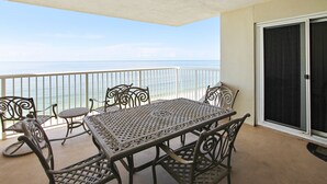 A balcony with a table and chairs, overlooking the sea. - Sandy Key 716: 2 BR / 2 BA Gulf Front Condo in Perdido Key, FL.  Sleeps 6 (Pensacola)