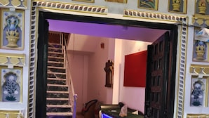A grand entrance with a marble staircase, a reception desk with a digital display, and ornate wall decorations. - The Rustic Monk (Udaipur)
