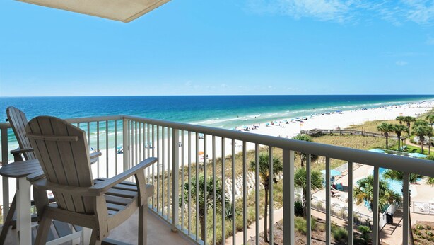 A balcony with a view of a beach and ocean.