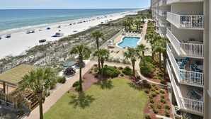 A beachfront hotel with a pool, beach access, and a view of the ocean.