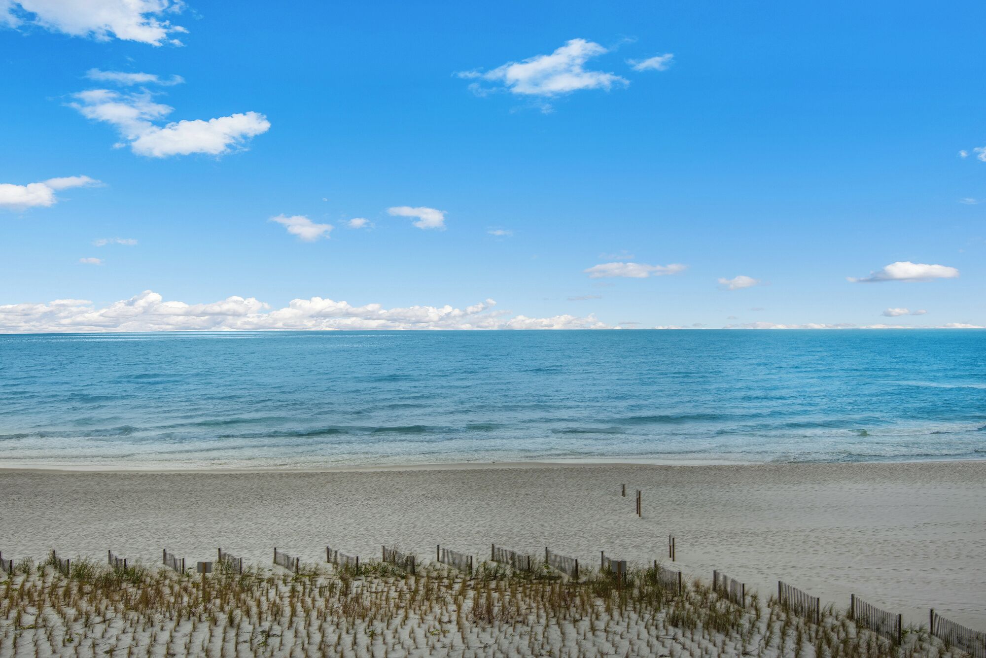 A beach with a clear sky and calm sea.