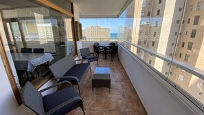 Enjoy the city view from this balcony with a table and chairs.