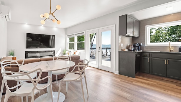 Una cocina moderna con comedor, ventanas amplias y vistas al exterior.