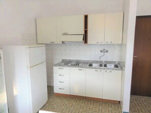 Kylskåp, mikrovågsugn, spishäll och grytor/köksredskap