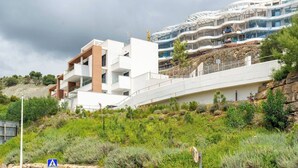A modern building with multiple balconies and a construction crane in the background. - La Quinta 3 bedroom apartment with Private Hot Tub (Benahavís)