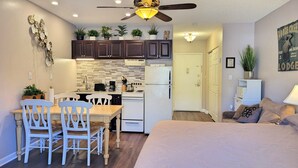 A compact kitchen with a dining area, a ceiling fan, and a bed with a large window. - Kitchen, AC, deck, view, pool, ski shuttle. LD 103 by LRS (Lincoln)
