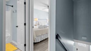 A hotel room with a bed, bedside lamp, and a view of the hallway. - Oceanside Condo in Atlantic Beach, NC-Anchors Away Unit 3 (Atlantic Beach)