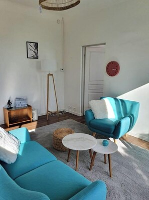 A living room with a teal sofa, a matching armchair, a small round table, and a lamp. - Quiet villa top with shared pool. Close to port and beaches. (Toulon)