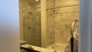 Bathroom features a glass-enclosed shower, separate bathtub, and vanity with mirror.
