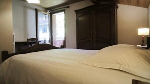A hotel room with a bed, a desk, a chair, a wardrobe, and a window. - 1st floor, view mountain, parking, tv, ski locker, 42m², Le Grand Bornand (Le Grand-Bornand)
