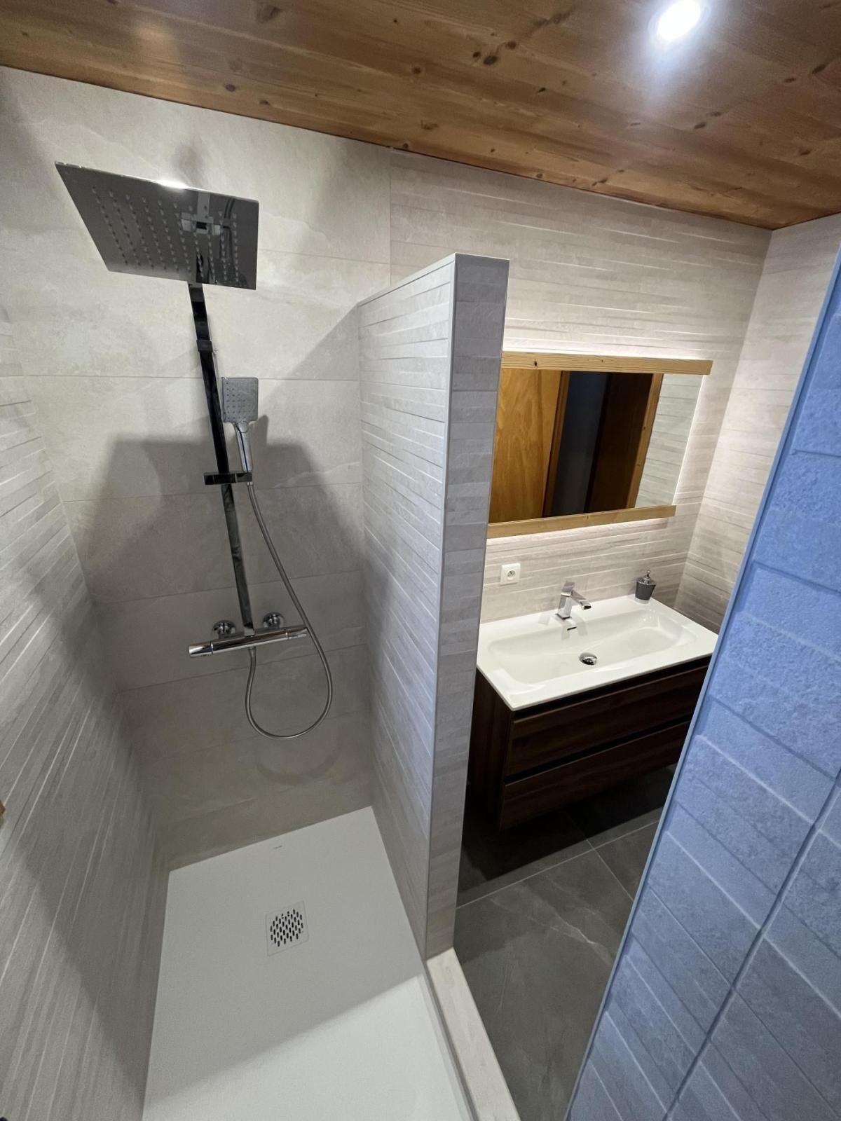 A modern bathroom with a shower, sink, and vanity.