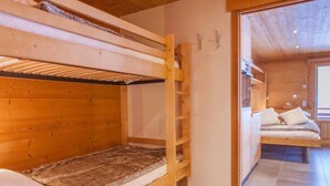 A wooden bunk bed room with a small desk and a window. - 3rd floor, balcony, parking, tv, 24m², Le Grand Bornand (Le Grand-Bornand)