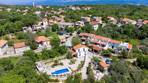 Vista aérea de una zona residencial con casas, una iglesia y una piscina.