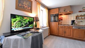 Eine Küche mit Holzausstattung, einem Herd und einem Fernseher auf einem Tisch.