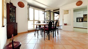 Un comedor con una mesa, sillas, un armario y vistas por la ventana.