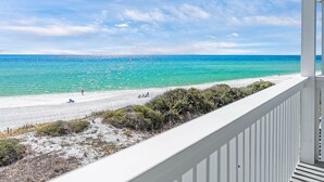 A beach view from a balcony with a clear sky and turquoise sea. - Gulf View Townhome | Prime Beach Location, Walk to Multiple Restaurants! (Santa Rosa Beach)