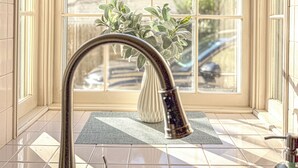 A bathroom with a window, a sink, and a vase with plants. - Groton Bay / Heated pool opens May 6th 2023! (Groton)