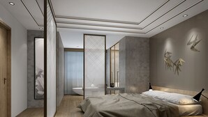 A modern bedroom with a large bed, a bedside table, a nightstand, a wall-mounted lamp, and a bathroom with a bathtub and a toilet.