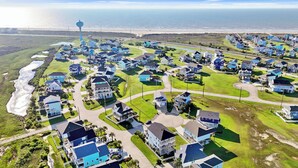 A coastal residential area with houses, a water tower, and a beach.