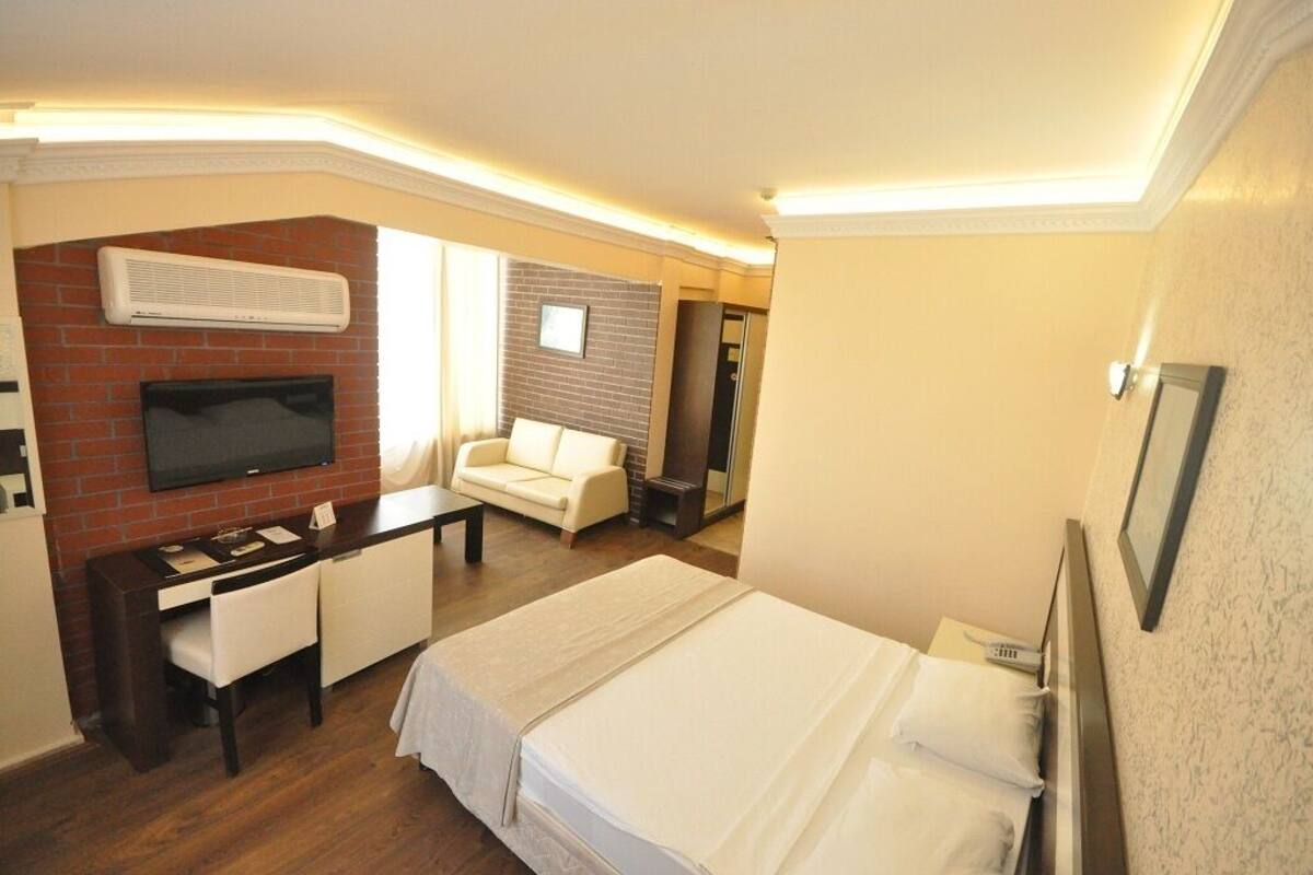 Une chambre d’hôtel équipée d’un lit, d’un bureau, d’une chaise, d’une télévision et d’une cheminée.