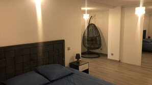 Ein Schlafzimmer mit einem Bett, einem Hängestuhl und einem Nachttisch.