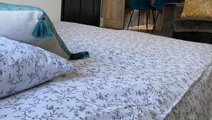 Una camera da letto con un letto, una scrivania e una sedia. Si nota una porta e una mappa incorniciata appesa al muro.
