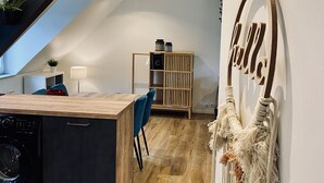 Una cucina moderna con piano in legno, lavatrice integrata e una scala che conduce a un livello superiore.
